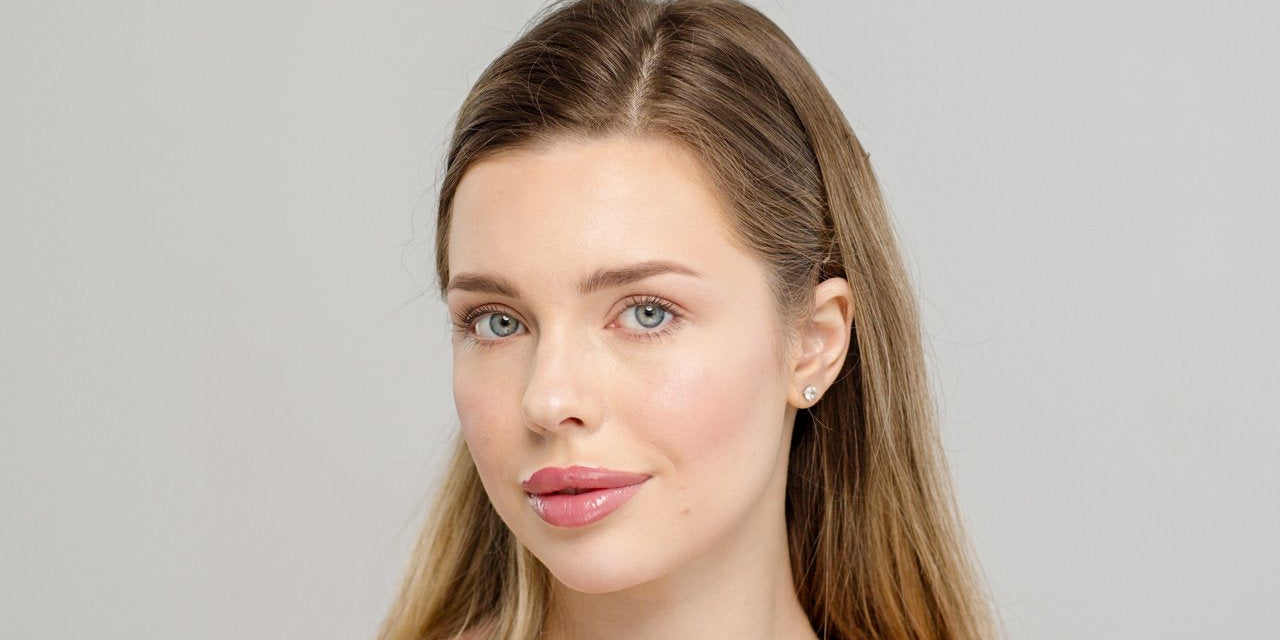 model with natural makeup wearing soft pink sheer lipstick and smooth glowing skin
