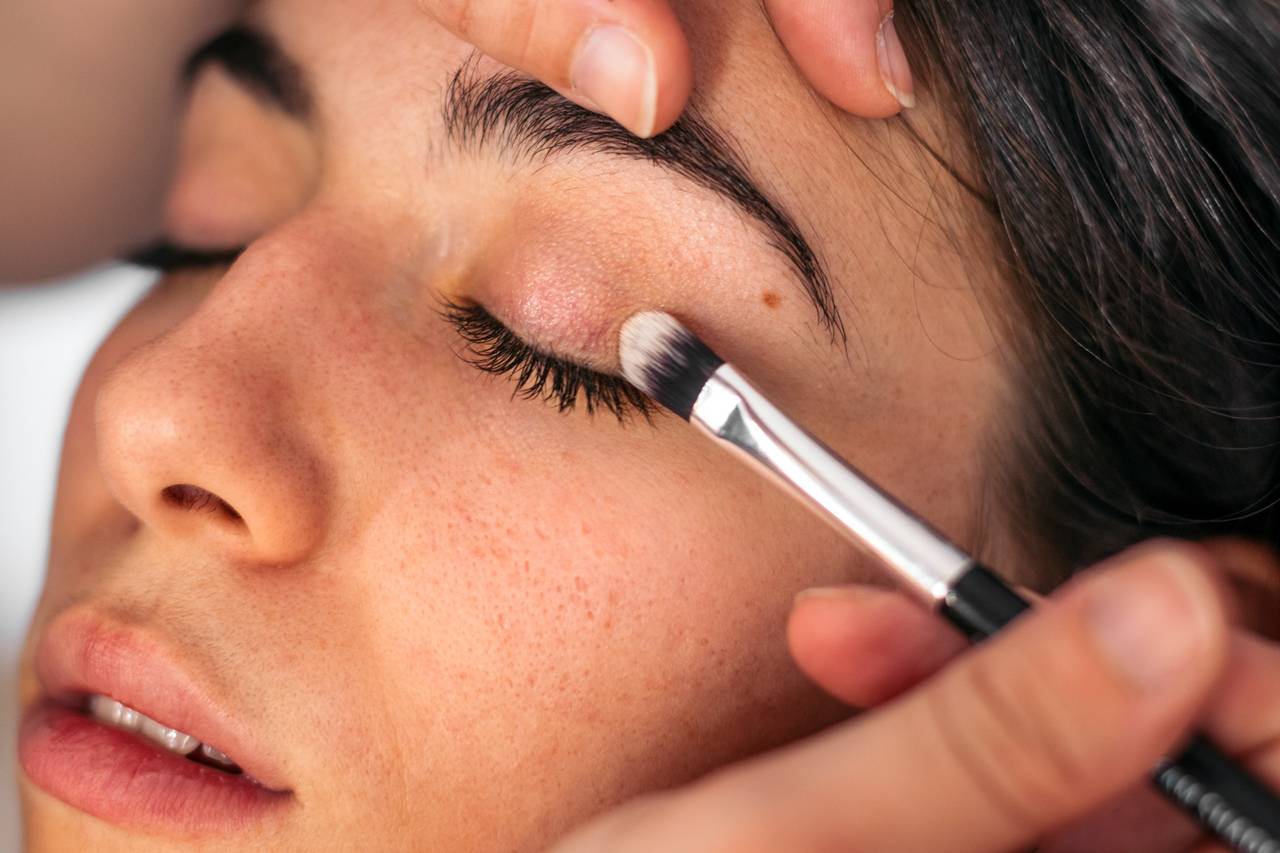 soft peach shimmer eyeshadow applied on the eyelid with a flat brush, close-up