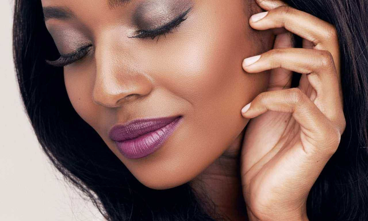 woman with shimmer eyeshadow and plum lipstick showing smooth crease-free eye makeup base