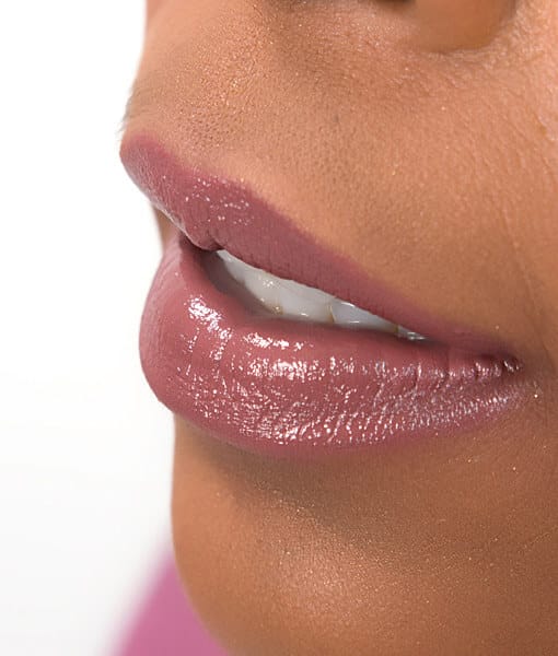 Image of close up lips on a dark skin tone lady wearing lipstick in the shade called Ooh La La by Red Apple Lipstick. Ooh La La is dusty rose shade that is slightly pink, slightly brown