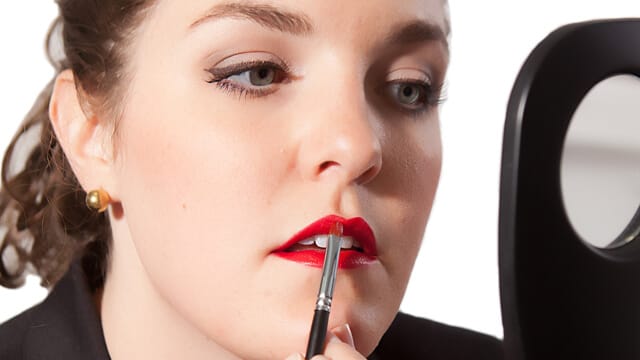 photo of a girl using a lipstick brush