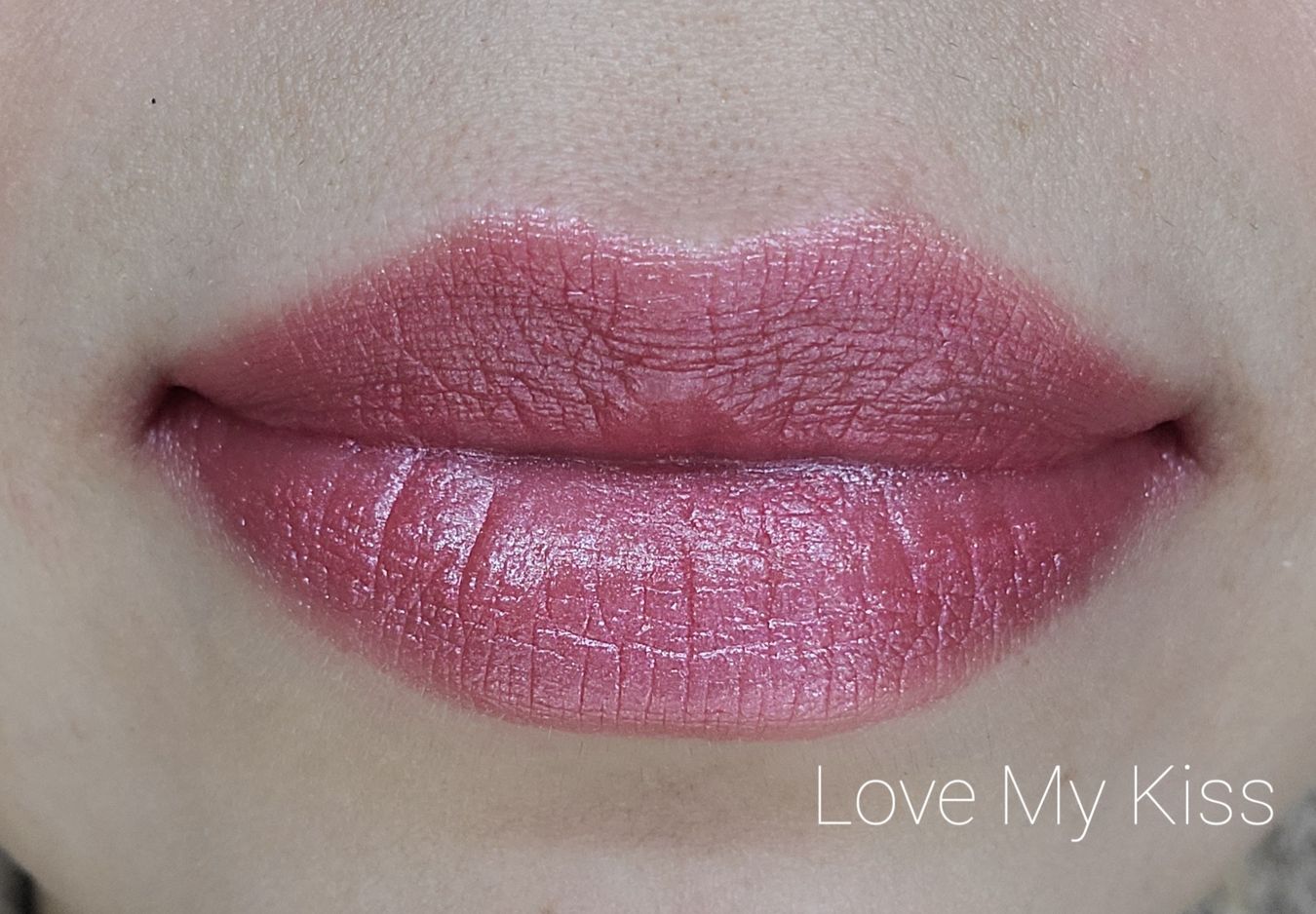 Image of close up lips wearing the lipstick in the shade called Love My Kiss. Pink red shade with subtle shimmer.