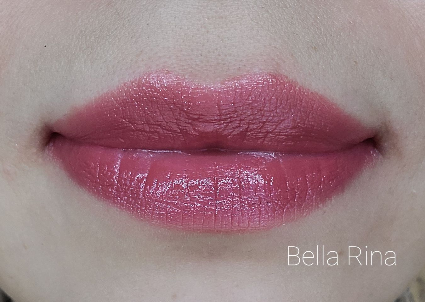 Image of close up lips wearing the shade called Bella Rina. A warm medium pink.