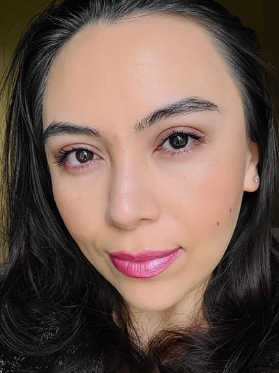Image of female model with long black hair, dark eyebrows and dark brown eyes. She is wearing a beautiful glow of her makeup look using blush and bronzer to brighten and contour her face
