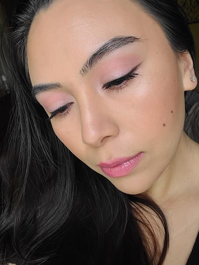 Image of female with long black hair wearing Red Apple lipstick in the shades Porcelain, On Pointe, Tutu Cutie, and Innocence with Black Eyeliner Pencil topped with Black Magic eyeshadow too. On her face she is wearing Sundrop Bronzer and M'Lady Blush showing wedding makeup tips