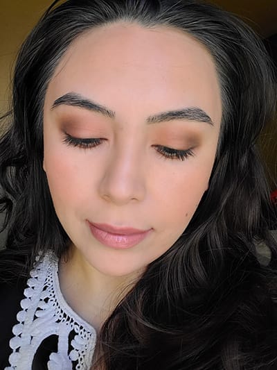 Image of female with long black hair wearing Red Apple Lipstick eyeshadows in the shades Porcelain, She's Spicy, Hush Hush, and Brownie Points. The Lash Project Mascara , Sundrop Bronzer and Tango Blush