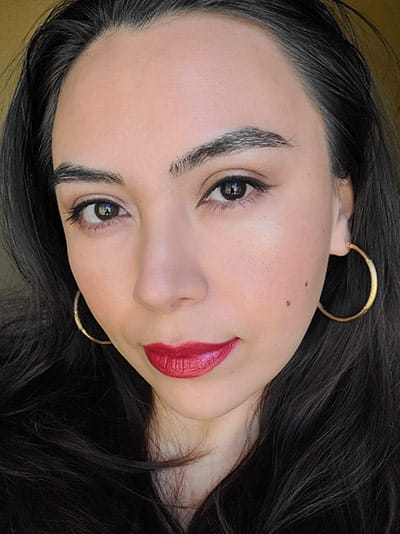 Image of lady with long dark hair, dark brown eyes and dark brows with medium skin tone. She is wearing Risque lipstick, Sundrop Bronzer and Coy Blush with the Shimmer Palette for Brown Eyes and The Lash Project Mascara by Red Apple Lipstick.
