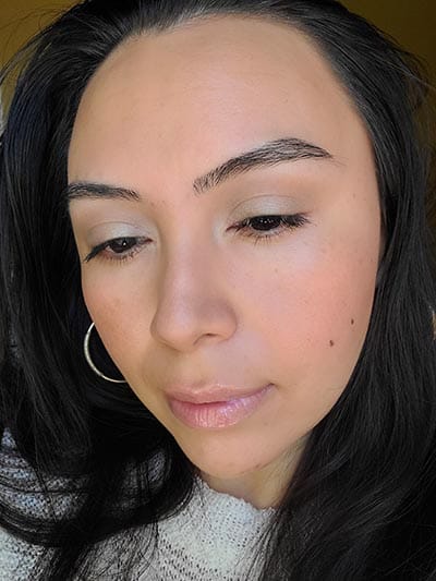 Image of lady with long dark hair, dark eyes and brows with medium skin tone. She is featured here looking to her right and eyes looking downward after completing the Ethereal and Natural Summertime makeup look. All with Red Apple lipstick products.