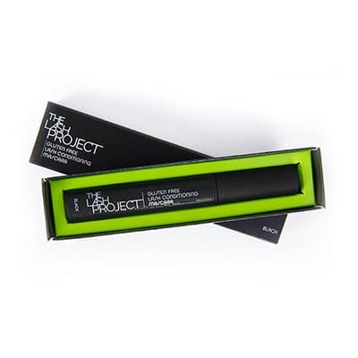 Image of The Lash Project Mascara in it's original packaging with the top casing slid off and placed underneath the product