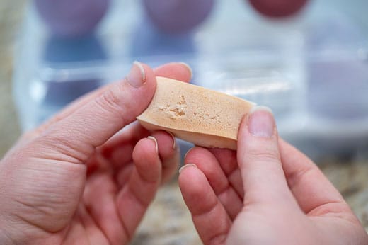 White triangle makeup sponge is destroyed right away by the first washing